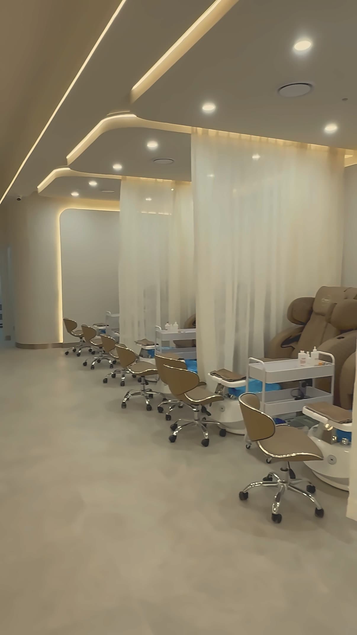 Pedicure alcoves: massage chairs in a row behind sheer curtains